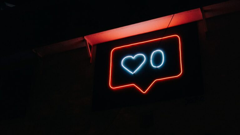 A glowing neon sign of a social media like notification with a heart and a zero
